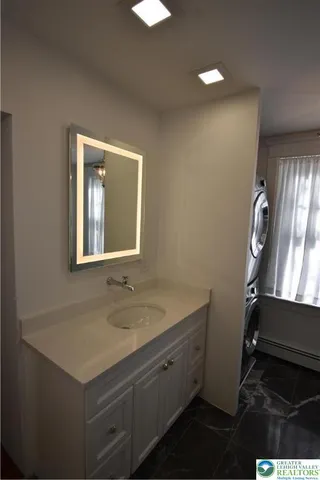 a bathroom with a sink vanity and a mirror