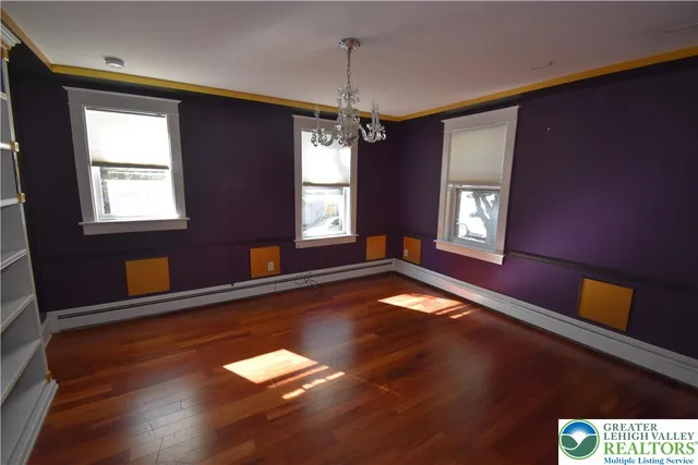 a view of empty room with window and wooden floor