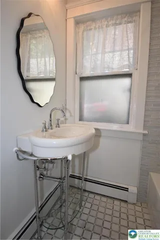 a bathroom with a sink a mirror and a window