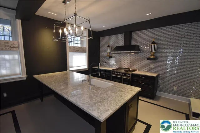 a kitchen with a kitchen island a stove and a wooden floor