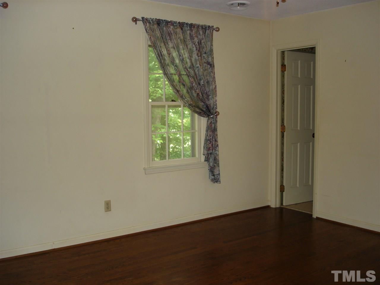 4516 Oak Park Road Raleigh, NC 27612 - Photo 13 of 17 an empty room with wooden floor and windows