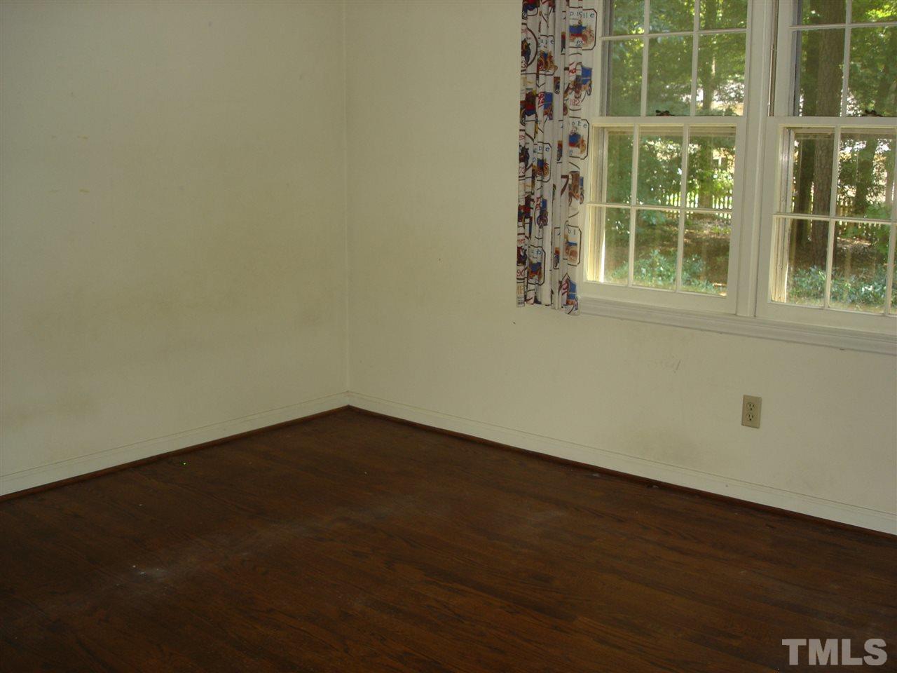 4516 Oak Park Road Raleigh, NC 27612 - Photo 17 of 17 an empty room with wooden floor and windows