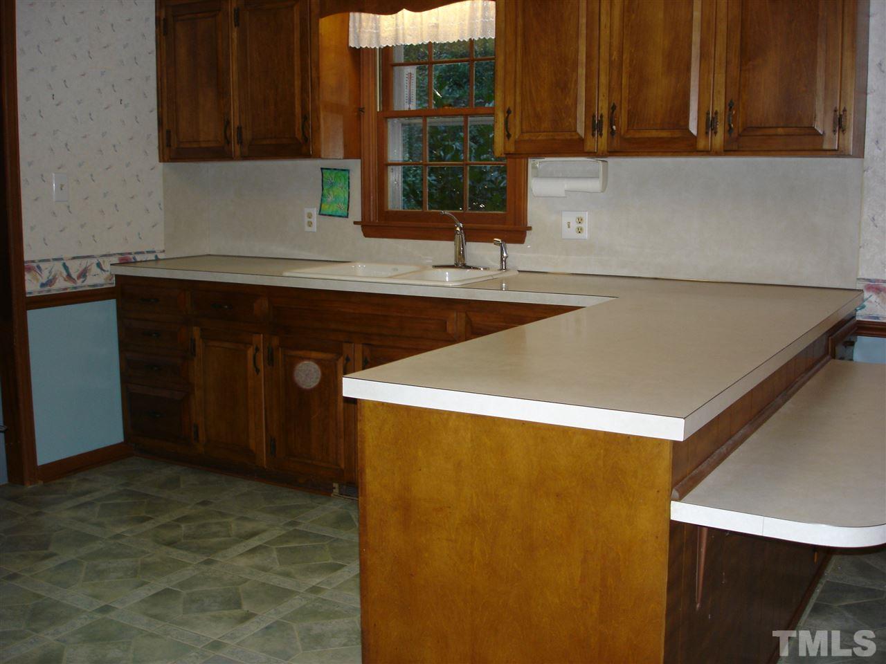 4516 Oak Park Road Raleigh, NC 27612 - Photo 7 of 17 a kitchen with a sink and a refrigerator