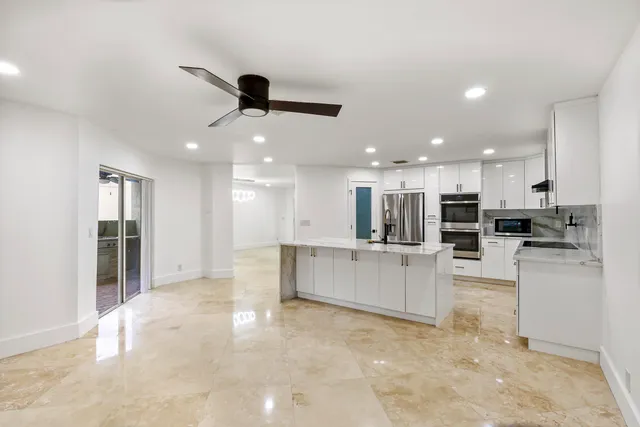 a view of kitchen with kitchen island white cabinets and refrigerator