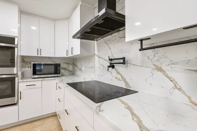 a kitchen with a sink a microwave and cabinets
