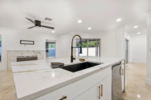 a kitchen with a sink a stove and white cabinets