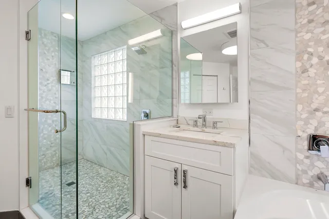 a bathroom with a shower sink and mirror