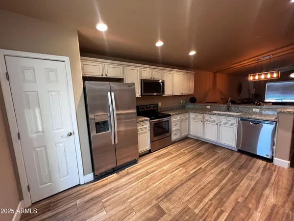 a kitchen with stainless steel appliances granite countertop a refrigerator and a stove top oven