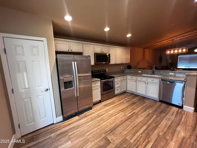 a kitchen with stainless steel appliances granite countertop a refrigerator and a stove top oven