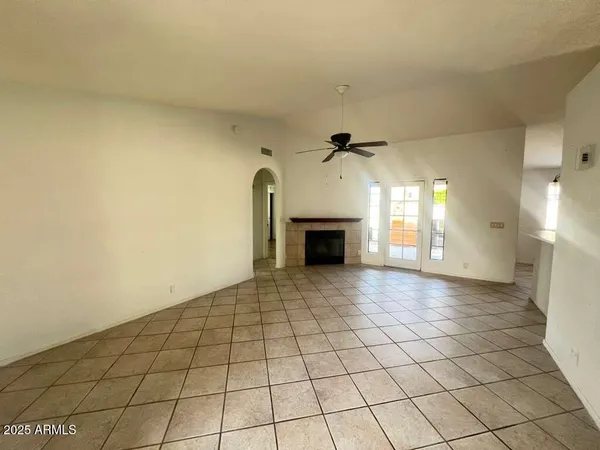 a view of empty room with a fireplace and fan