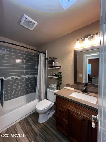 a bathroom with a sink a toilet a mirror and shower