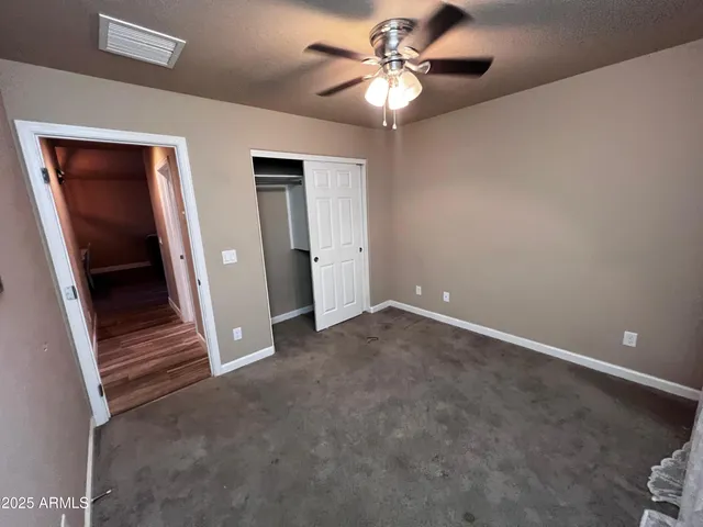 a view of an empty room with a ceiling fan