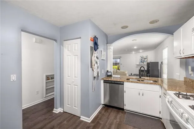 a kitchen with a sink a refrigerator and wooden floor