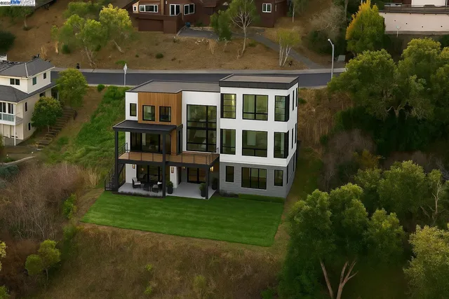 an aerial view of residential houses with yard and lake view