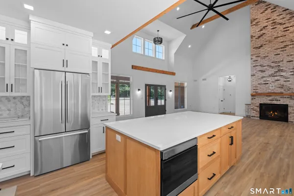 a kitchen with stainless steel appliances a refrigerator and a fireplace
