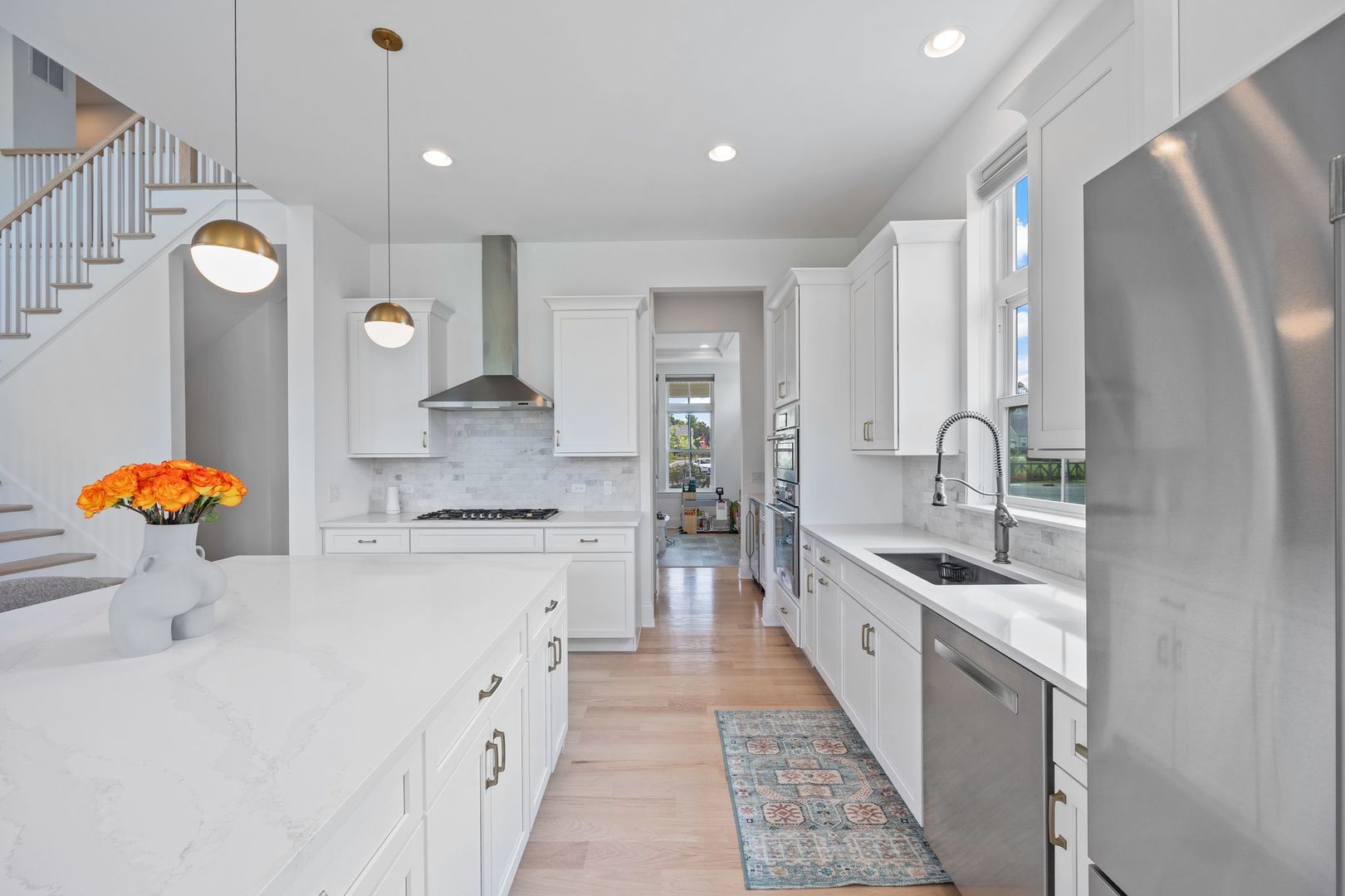 2834 Parkside Circle Glenview, IL 60026 - Photo 14 of 59 a large kitchen with stainless steel appliances a stove a sink dishwasher and white cabinets with wooden floor