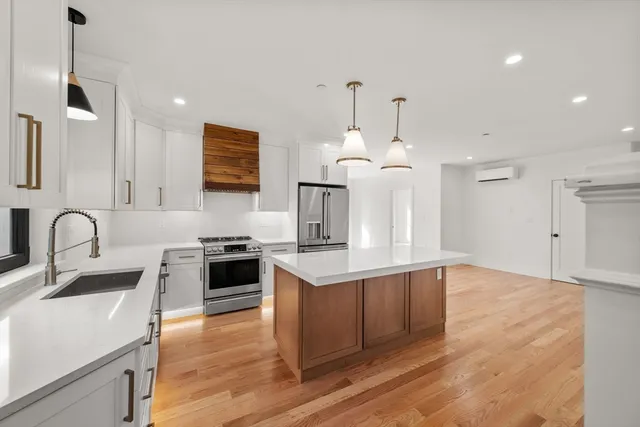 a kitchen with kitchen island a sink stainless steel appliances and cabinets