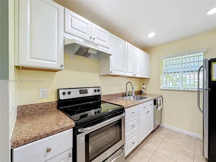 a kitchen with stainless steel appliances granite countertop a sink a stove and a refrigerator