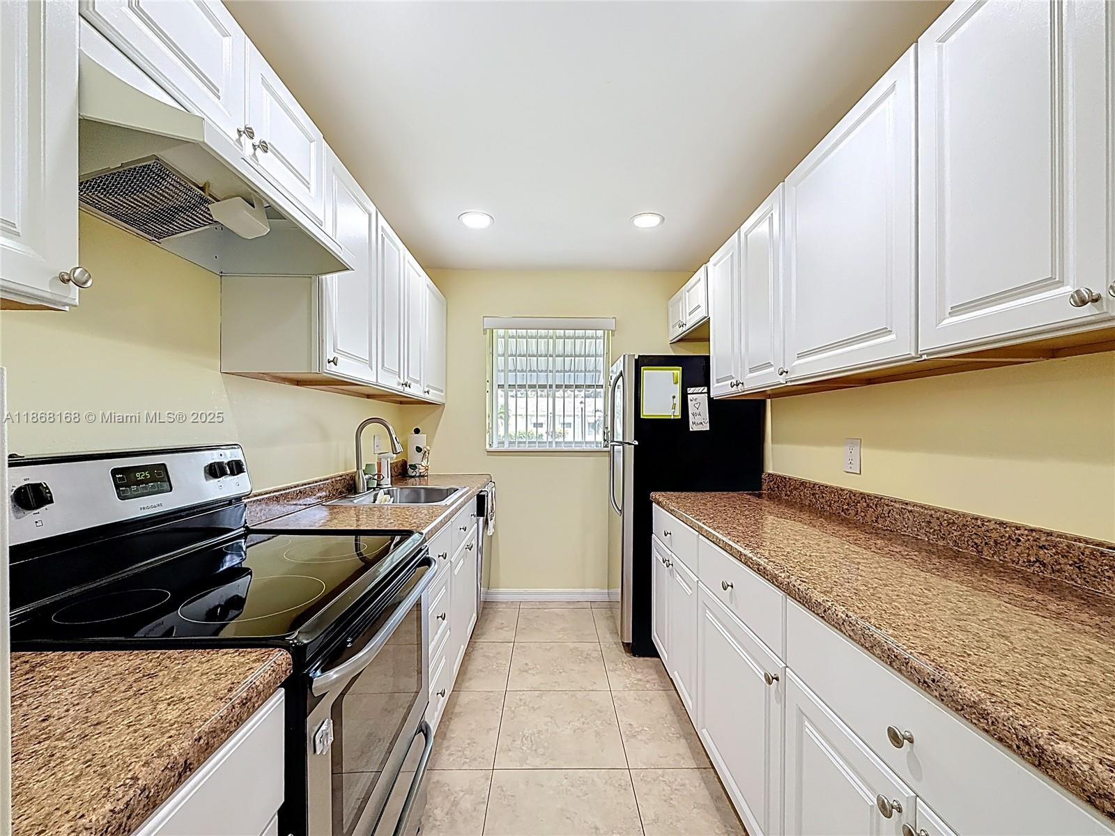 290 Main Boulevard, Unit C Boynton Beach, FL 33435 - Photo 17 of 56 a kitchen with stainless steel appliances granite countertop a sink a stove and a refrigerator