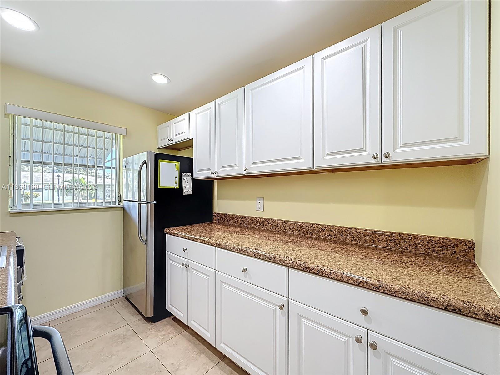 290 Main Boulevard, Unit C Boynton Beach, FL 33435 - Photo 18 of 56 a kitchen with stainless steel appliances granite countertop a coffee maker a sink and cabinets