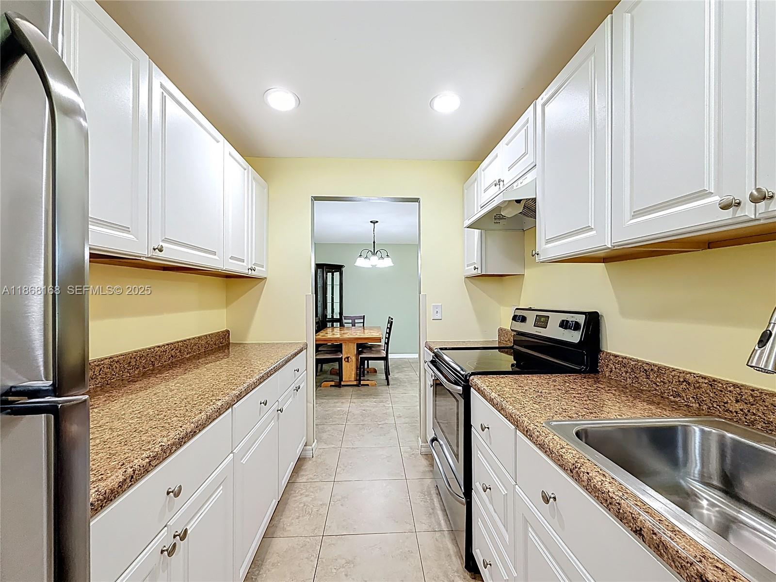 290 Main Boulevard, Unit C Boynton Beach, FL 33435 - Photo 19 of 56 a kitchen with stainless steel appliances granite countertop a sink stove and refrigerator