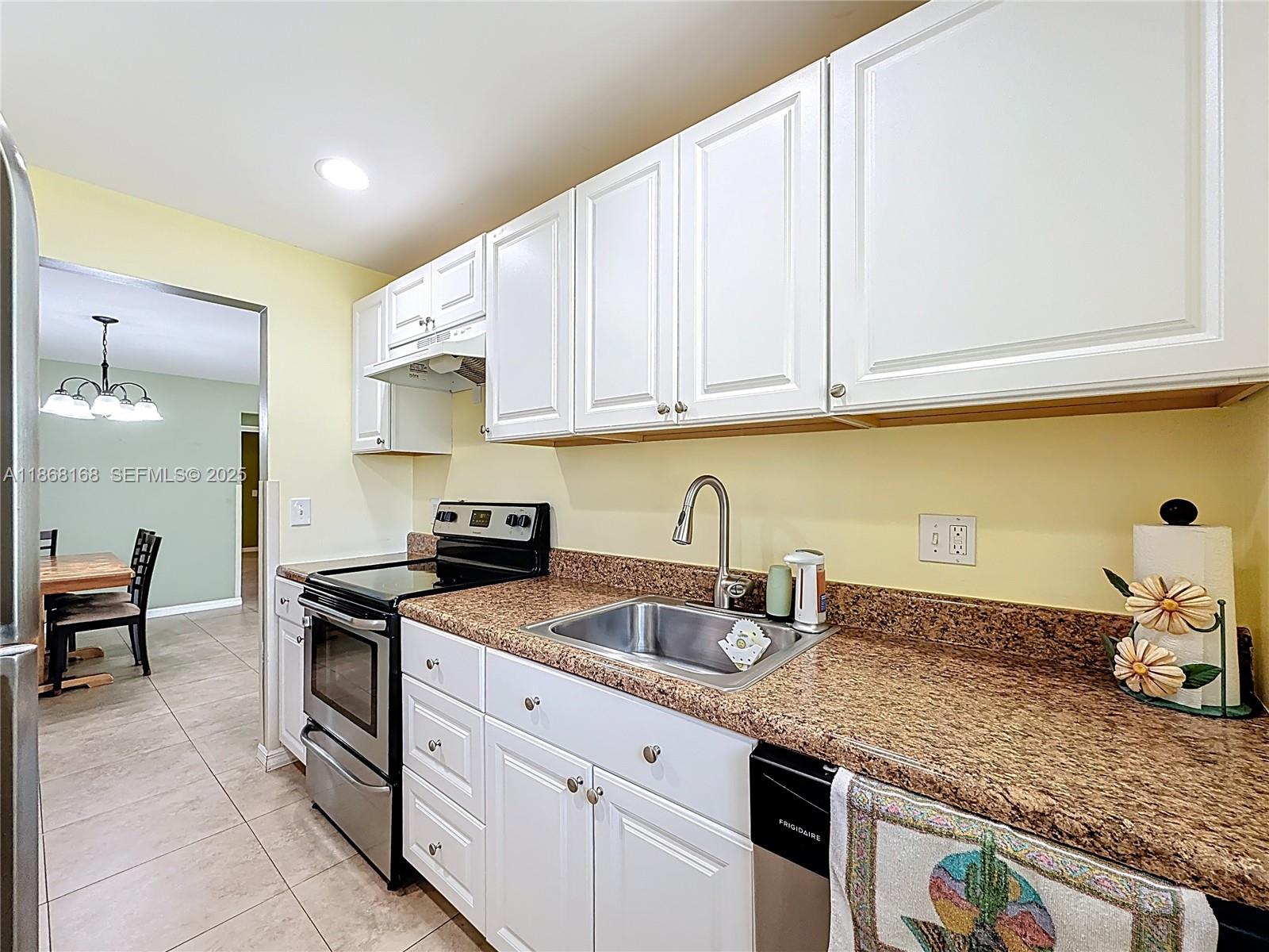 290 Main Boulevard, Unit C Boynton Beach, FL 33435 - Photo 21 of 56 a kitchen with granite countertop a sink a stove and cabinets