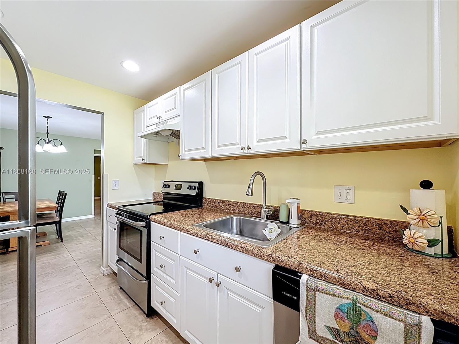 290 Main Boulevard, Unit C Boynton Beach, FL 33435 - Photo 22 of 56 a kitchen with granite countertop a sink a stove and cabinets