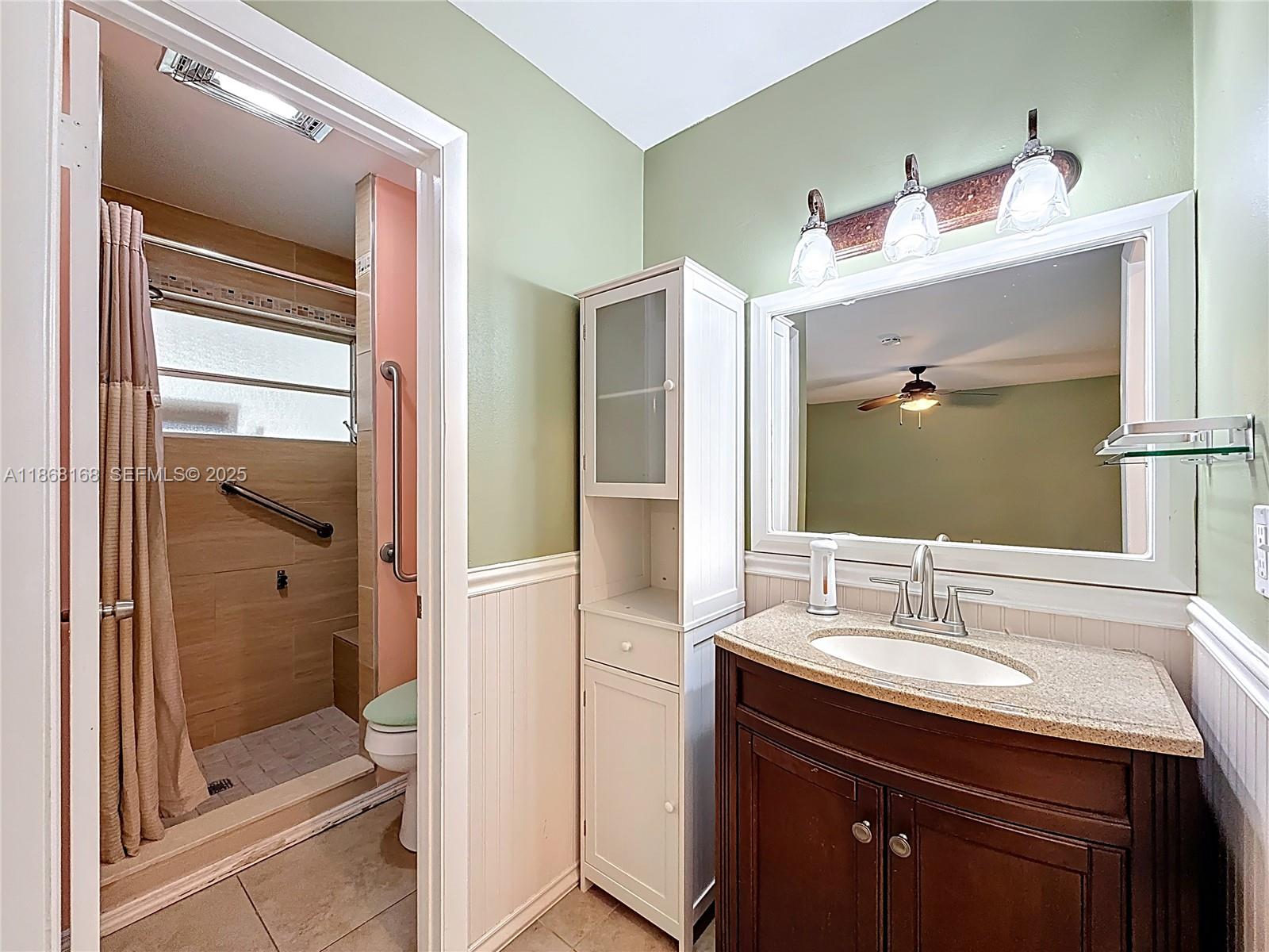 290 Main Boulevard, Unit C Boynton Beach, FL 33435 - Photo 32 of 56 a bathroom with a shower sink vanity and mirror