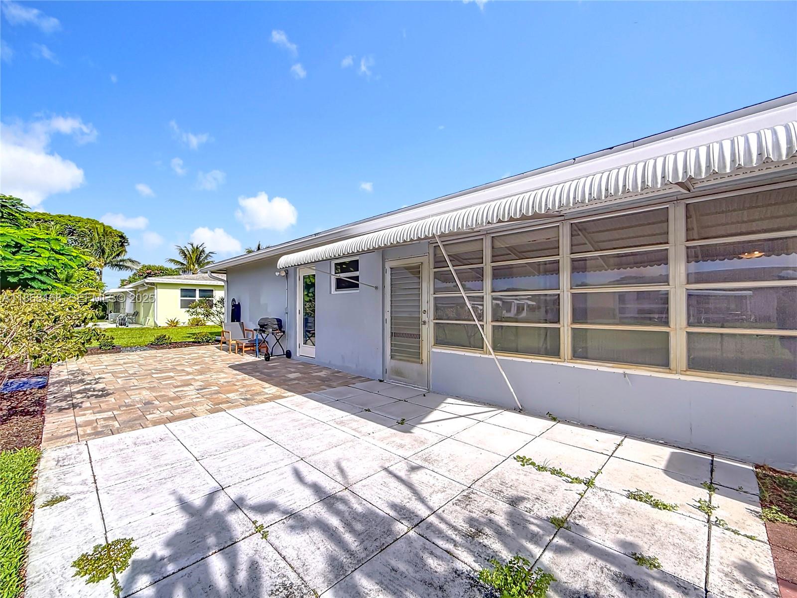 290 Main Boulevard, Unit C Boynton Beach, FL 33435 - Photo 43 of 56 a view of a house with a patio and a yard