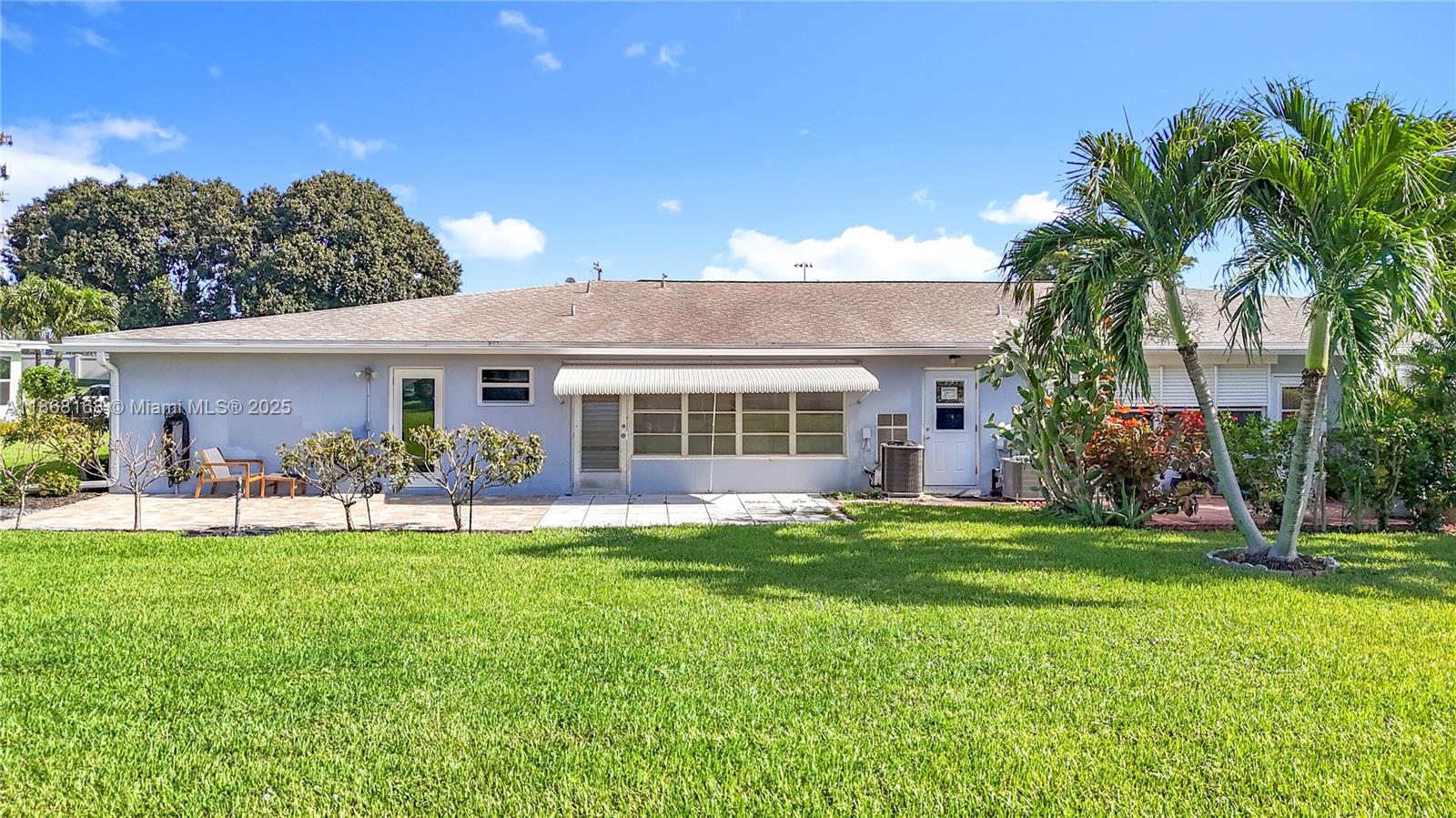 290 Main Boulevard, Unit C Boynton Beach, FL 33435 - Photo 47 of 56 a front view of a house with a garden and patio