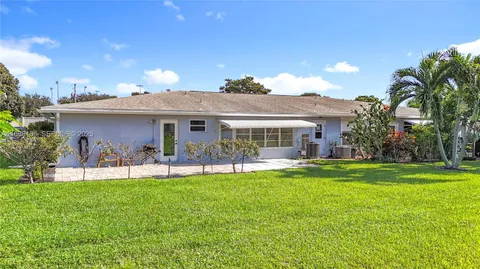an aerial view of multiple houses with a yard and lake view