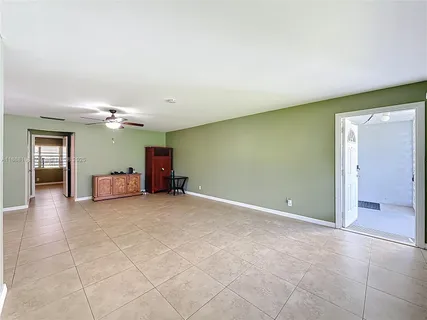 an empty room with a mirror and a ceiling fan