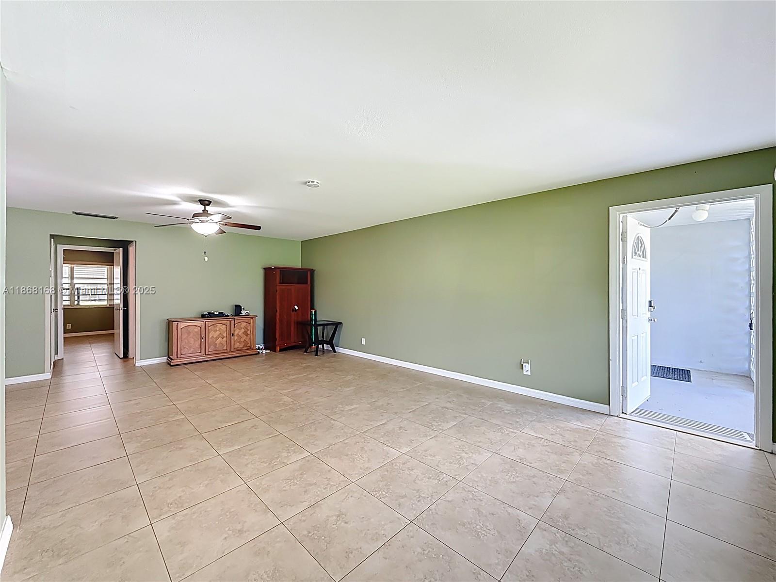 290 Main Boulevard, Unit C Boynton Beach, FL 33435 - Photo 6 of 56 an empty room with a mirror and a ceiling fan
