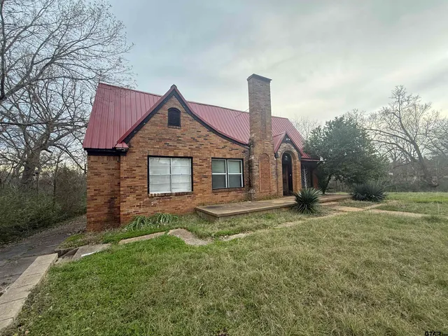 a front view of a house with a garden and yard