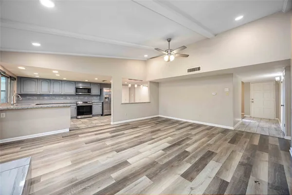 a view of a kitchen with kitchen island a sink stainless steel appliances counter space and cabinets