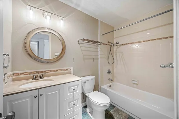 a bathroom with a granite countertop sink toilet mirror vanity and shower