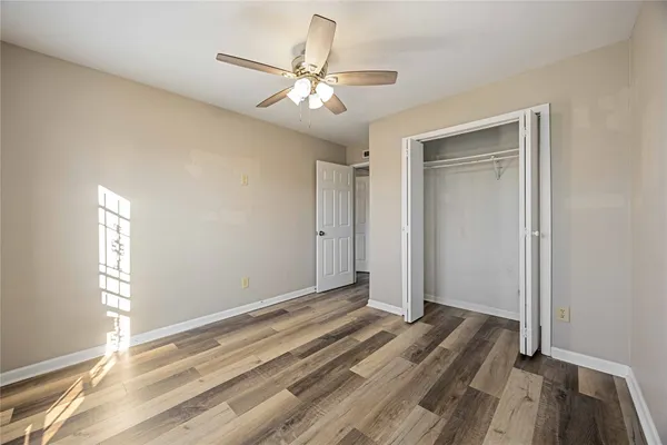a view of a livingroom with wooden floor and ceiling fan
