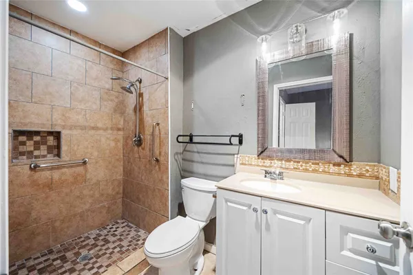 a bathroom with a sink toilet vanity and shower