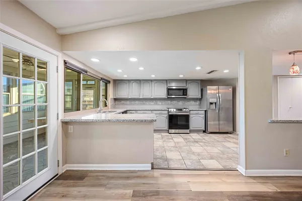 a large kitchen with a stove top oven and cabinets