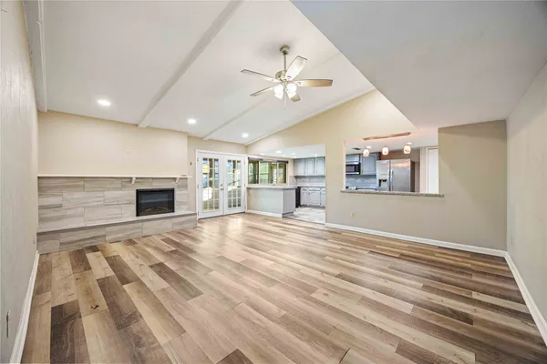 en empty room with wooden floor fireplace and fan