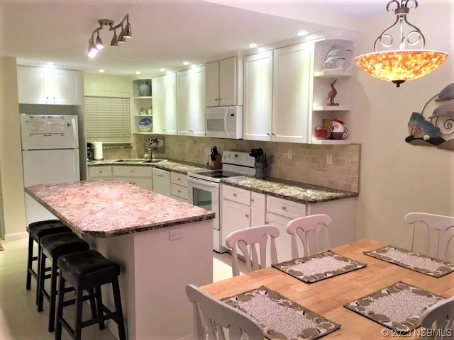 a kitchen with a table chairs and chandelier