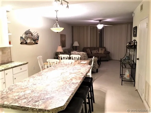 a very nice looking dining room with a kitchen island furniture and a chandelier