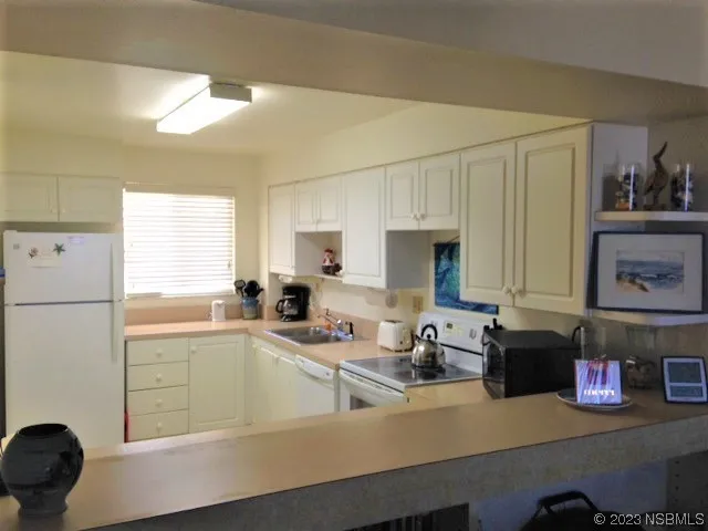 a kitchen with stainless steel appliances a sink a stove a refrigerator and cabinets