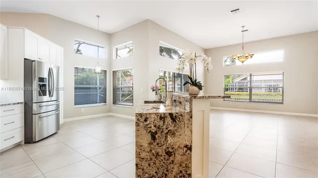 a view of a kitchen with refrigerator and window