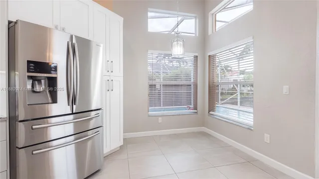 a kitchen with stainless steel appliances a refrigerator and a window
