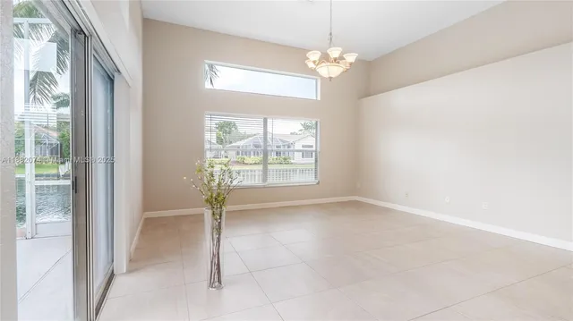 en empty room with windows and chandelier