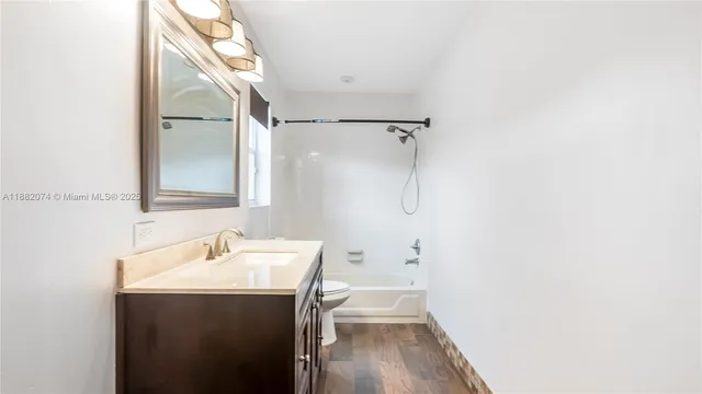 a bathroom with a sink and mirror with toilet