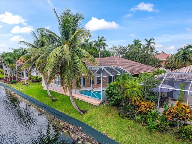 a front view of a house with a yard and potted plants