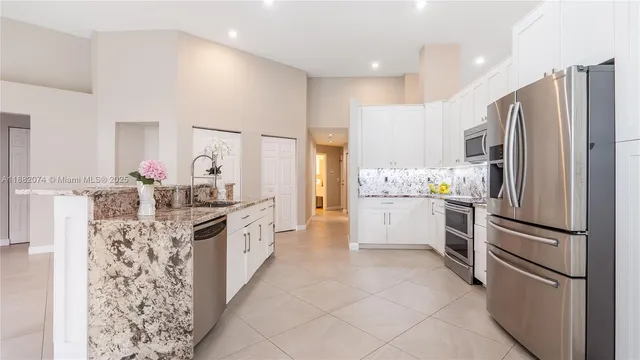 a kitchen with stainless steel appliances a refrigerator sink and cabinets