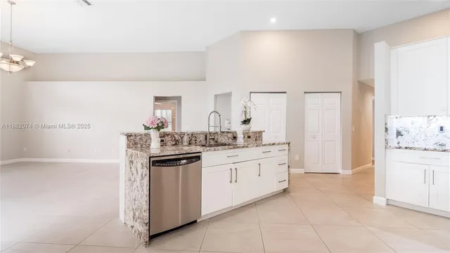 a kitchen with granite countertop a sink and cabinets